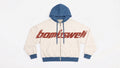 Sudadera con cremallera colorblock crema y azul con wordmark bombswell grande en el pecho